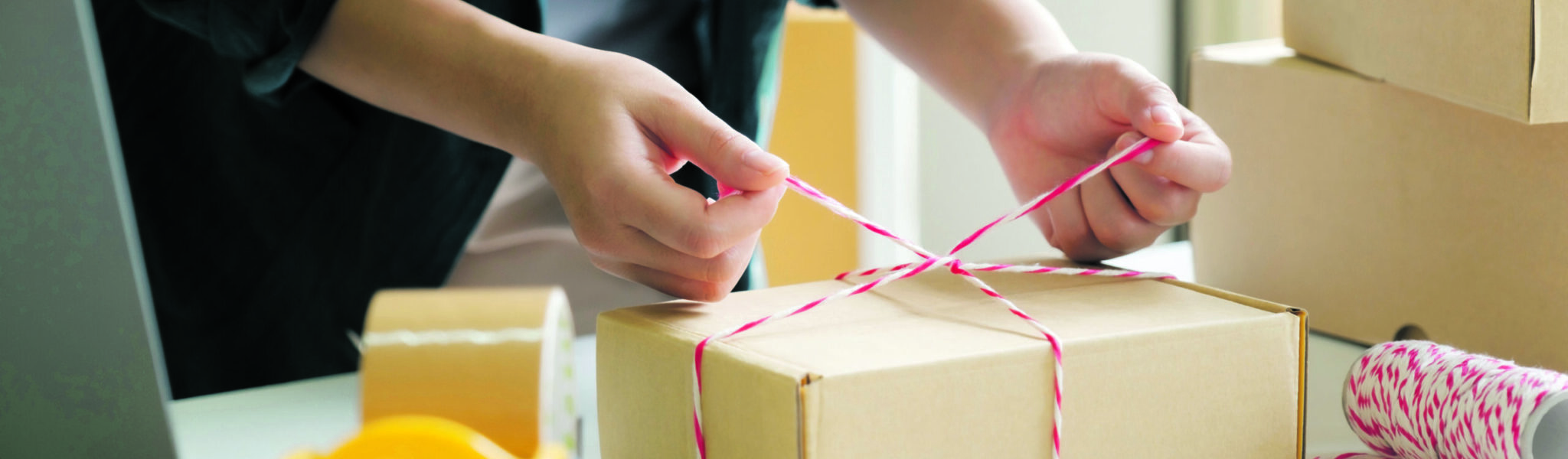 Vrouw Pakketverzending Spanje - Hoe je je zendingen veilig anparcel en vastbinden met touw voor verzending krijgt. Pakketverzending Spanje - Hoe uw zendingen veilig aankomen